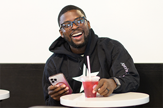 Thyshown sitting at table smiling