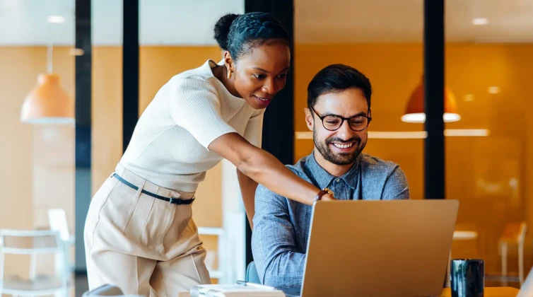 Woman pointing to something on colleagues computer