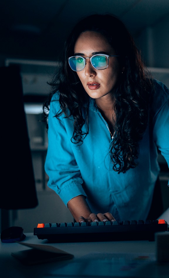 female cybersecurity professional looking at computer screen