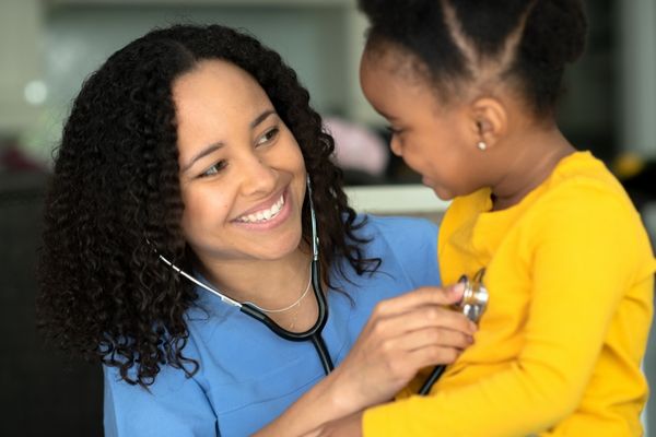 nurse examining pediatric patient with stethoscope