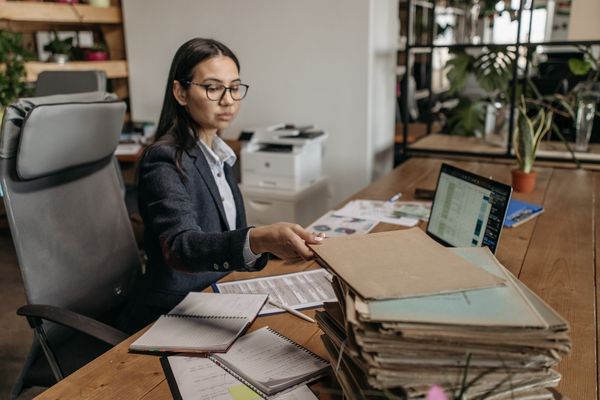 business administration professional sorting through documents at desk